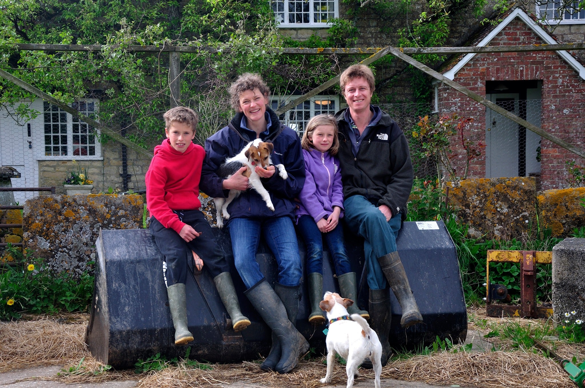 Family photo of the Primroses outside the farmhouse